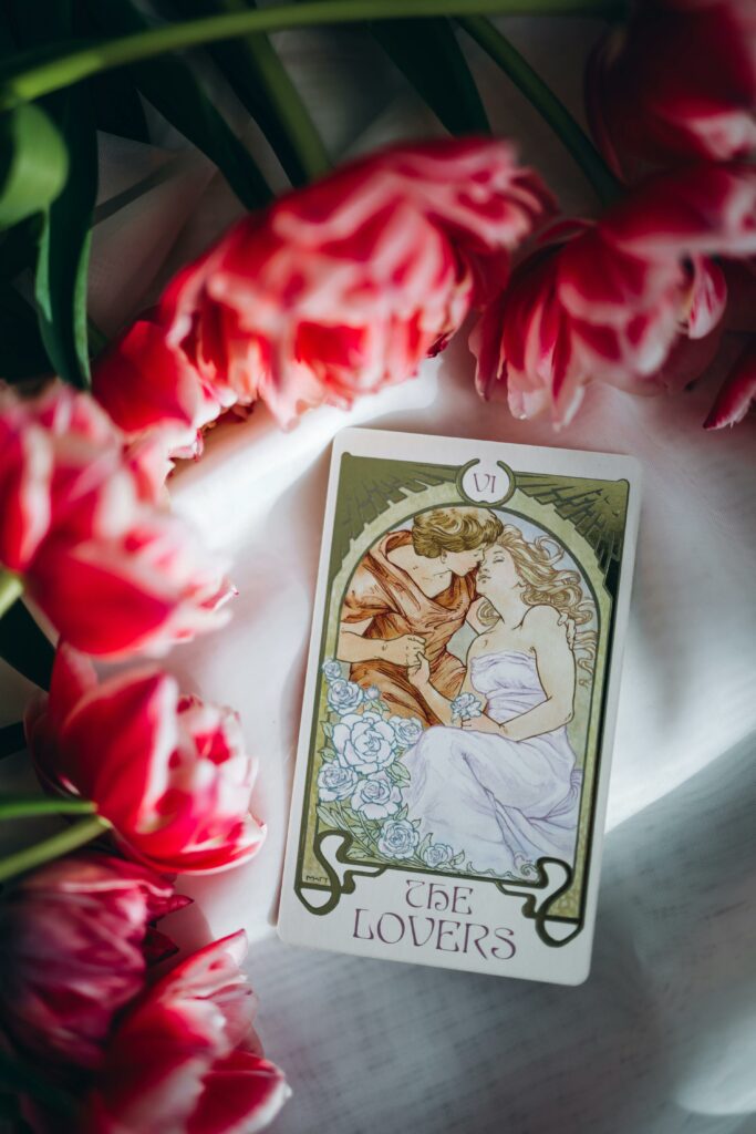 img-09-free-img.jpg The Lovers tarot card among vibrant pink tulips symbolizing love and harmony.